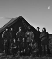 Archive image showing some of the first jackets worn by a group standing in front of a tent