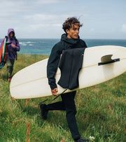 man-in-finisterre-clothing-holding-a-surf-board